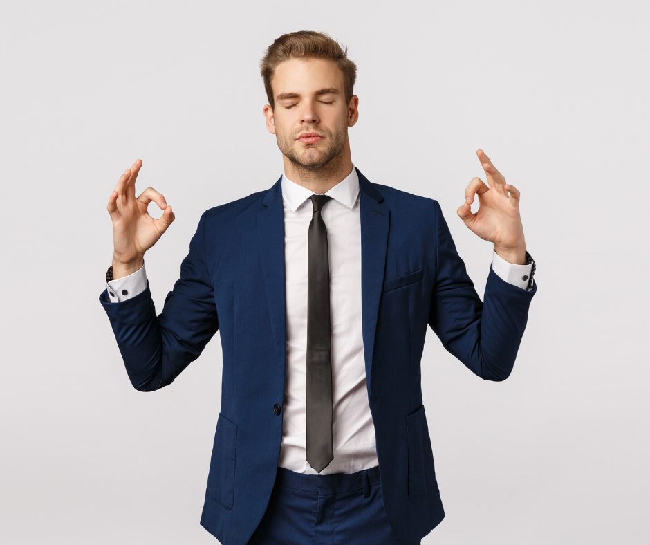 Man in suit taking a calming breath with fingers in "om"